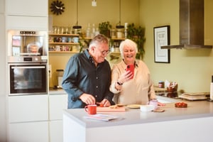 Old couple on their phone in the kitchen